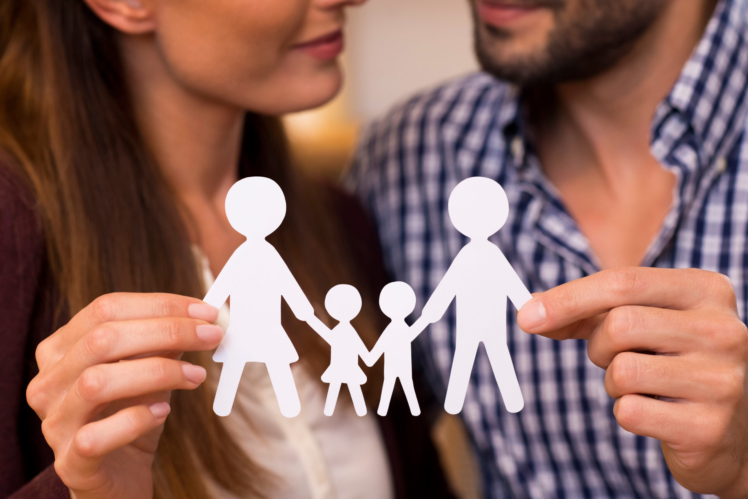 Close up of a couple holding paper man chain of a family