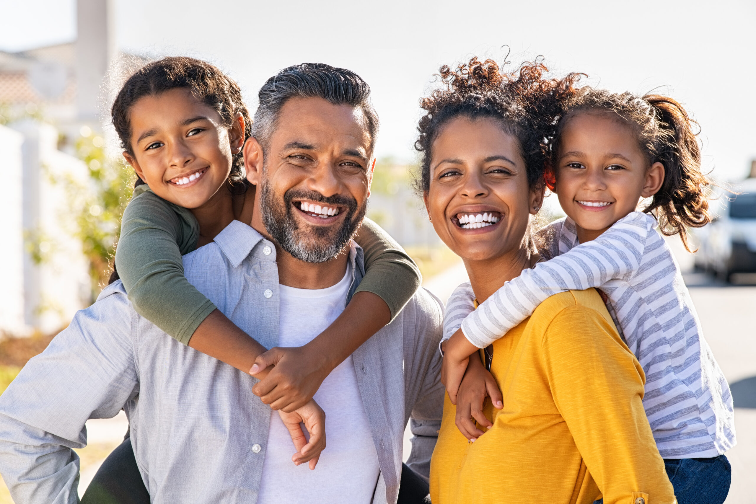 Hispanic family giving their children a piggyback ride