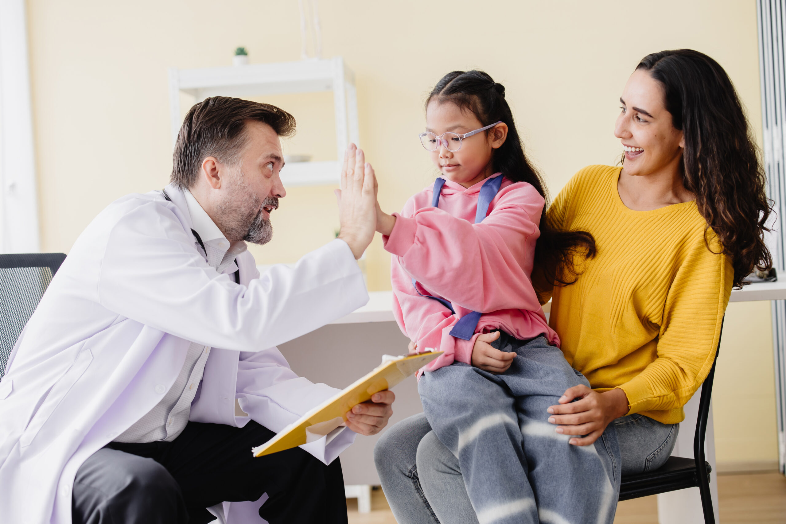 Mother with daughter meeting pediatrician doctor at the clinic for health check